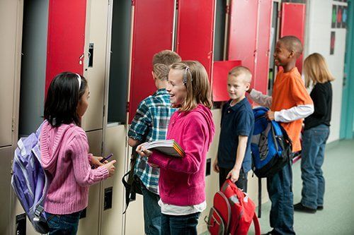 Children putting their things on the locker room